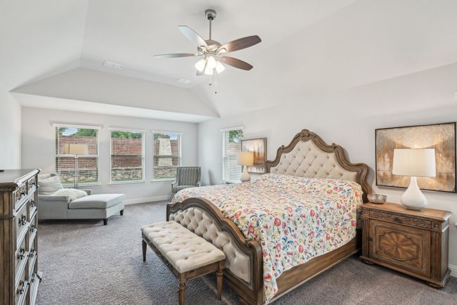 Bedroom featuring carpet, vaulted ceiling, sitting area, and a ceiling fan | Image 22