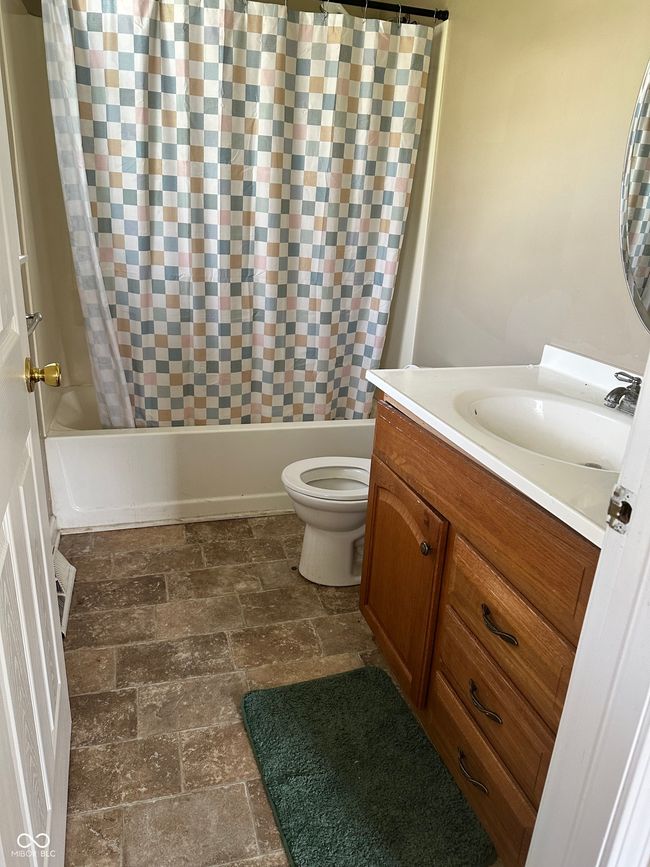 bathroom with vanity, shower / bath combo, and stone finish floors | Image 6