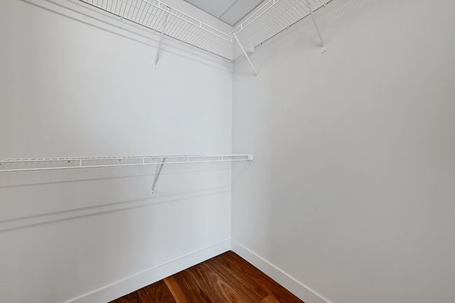 Spacious closet featuring dark wood-style flooring | Image 12