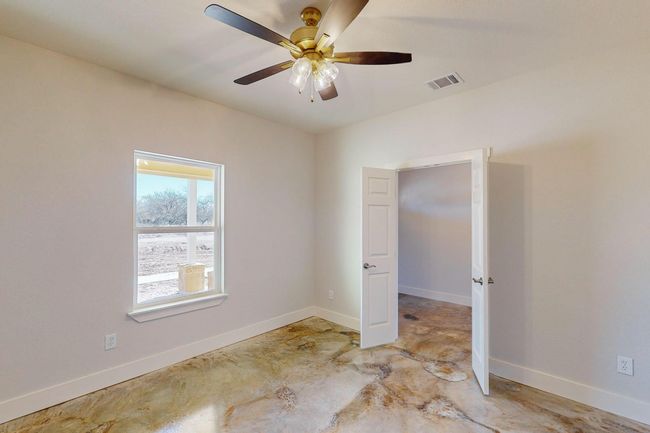 Empty room featuring ceiling fan and concrete flooring | Image 21