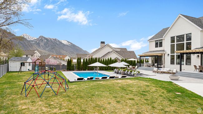 View of pool featuring a storage unit, a fenced in pool, an outbuilding, a fenced backyard, and a patio | Image 53