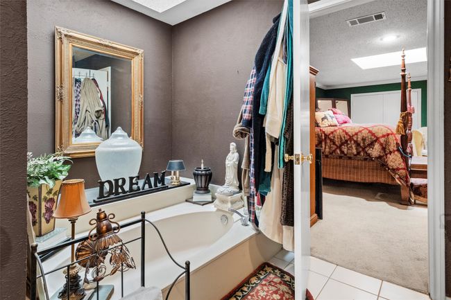 Ensuite bathroom with a washtub, ensuite bathroom, visible vents, a skylight, and tile patterned flooring | Image 18