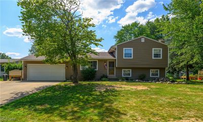 Split level home with a garage and a front lawn | Image 1