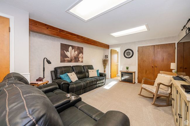 Carpeted living area with a glass covered fireplace | Image 23