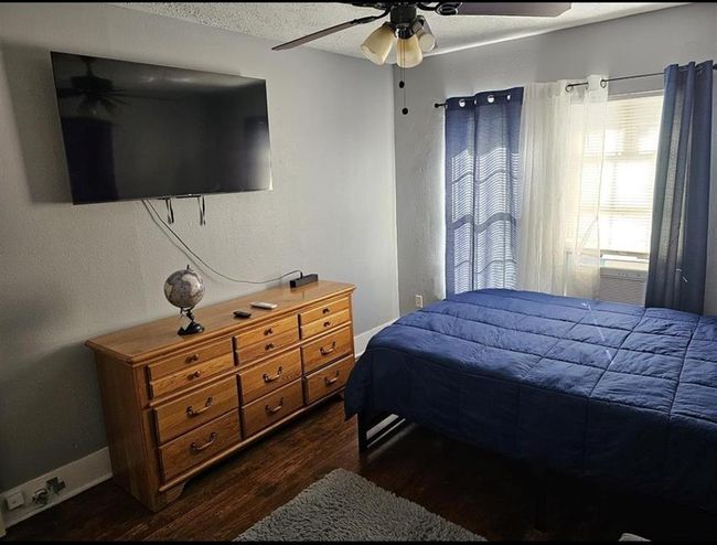 Cozy bedroom in a two-bedroom unit, featuring natural light and ample space for relaxation. | Image 12