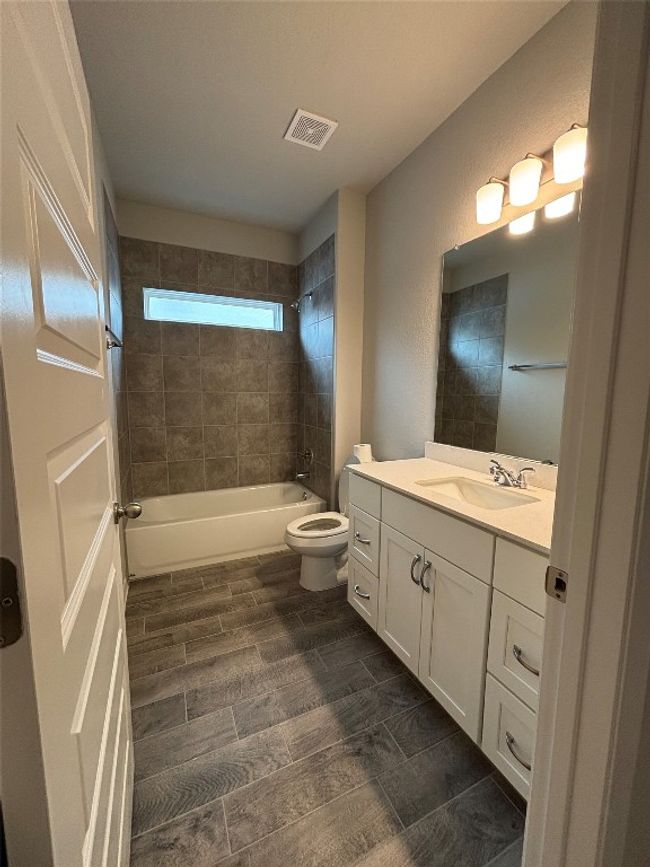Bathroom with vanity, toilet, and shower / bath combination | Image 11