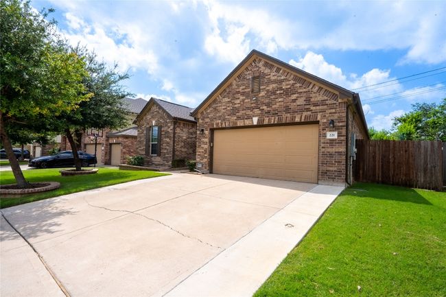 View of front of house featuring brick siding, an attached garage, and driveway | Image 35