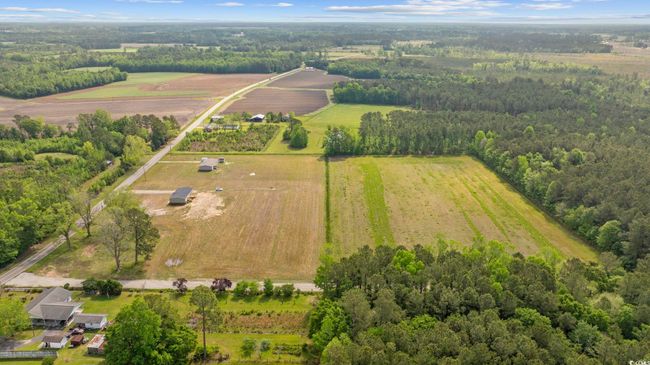 Aerial view of sparsely populated area with a heavily wooded area | Image 4