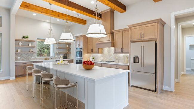 Kitchen with decorative light fixtures, stainless steel appliances, backsplash, light wood-style floors, and beam ceiling | Image 6