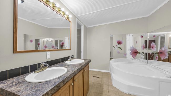 Full bath featuring double vanity, crown molding, a bath, and tile patterned flooring | Image 19