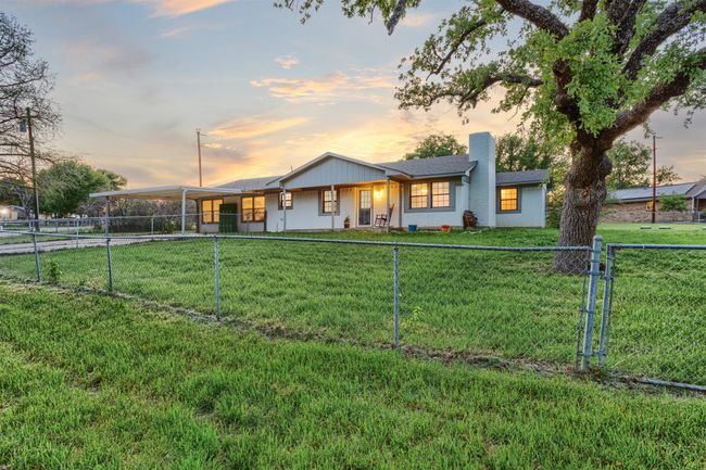 View of front of house with a lawn, a fenced backyard, a chimney, and an attached carport | Image 35
