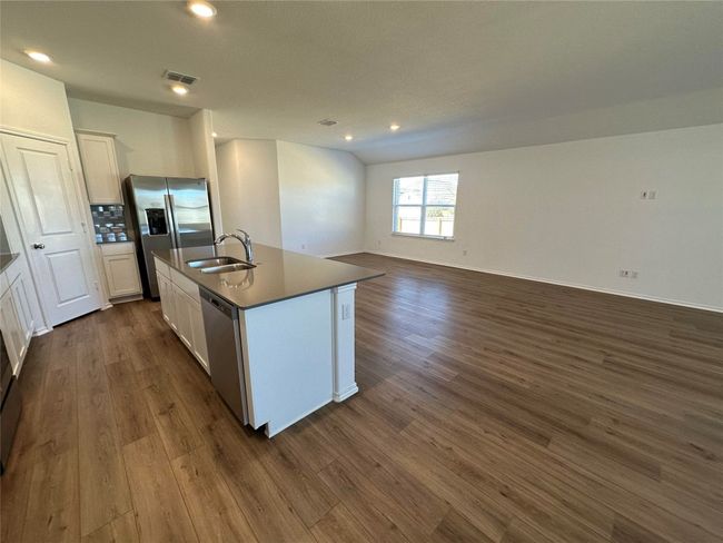 Kitchen with appliances with stainless steel finishes, a sink, open floor plan, dark wood-type flooring, and visible vents | Image 5