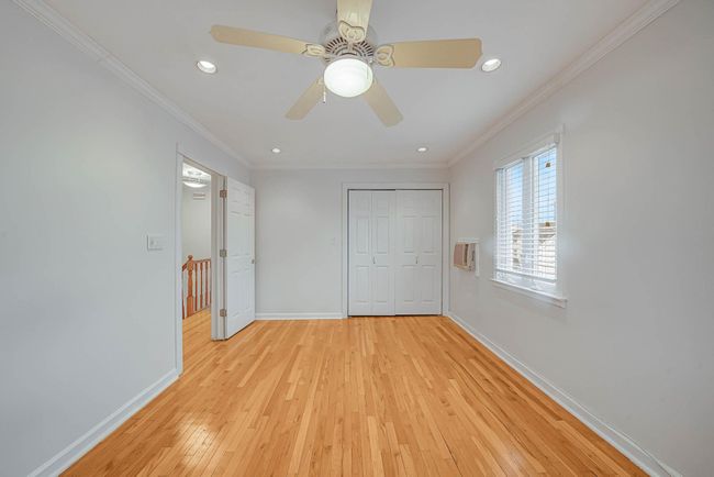 Unfurnished bedroom featuring a closet, ceiling fan, crown molding, and light hardwood / wood-style flooring | Image 17
