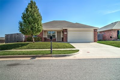 Ranch-style home with a front lawn and a garage | Image 1