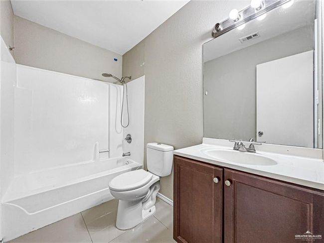 Full bathroom with toilet, shower / bathing tub combination, tile patterned floors, and vanity | Image 12