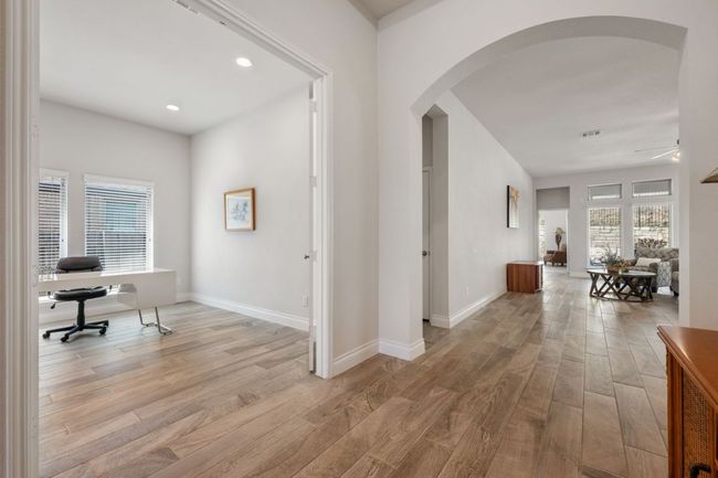 Hallway featuring arched walkways, light wood finished floors, and baseboards | Image 9