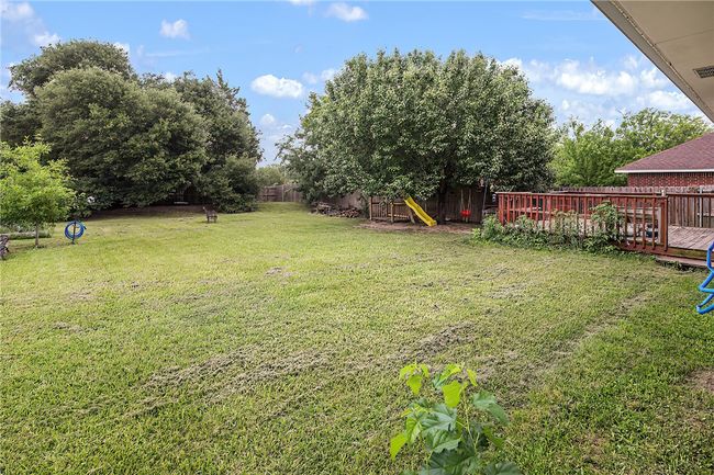 View of yard with a wooden deck and a playground | Image 23
