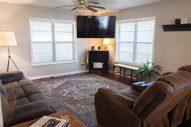 Living area with a ceiling fan and wood finished floors | Image 5