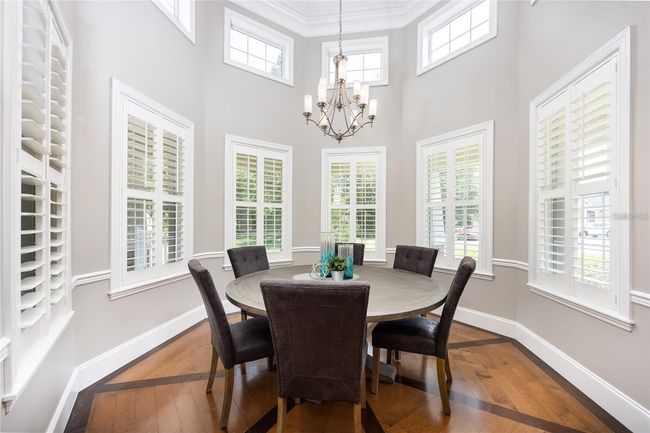 Stunning rotunda dining room with soaring ceilings and shutters with access to the wet bar near by ~ perfect for entertaining! | Image 11