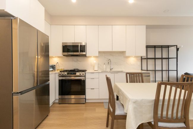 Kitchen featuring modern cabinets, a sink, stainless steel appliances, and white cabinets | Image 10