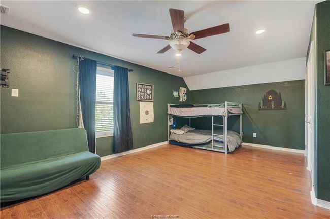 Bedroom with wood finished floors, recessed lighting, ceiling fan, and lofted ceiling | Image 22