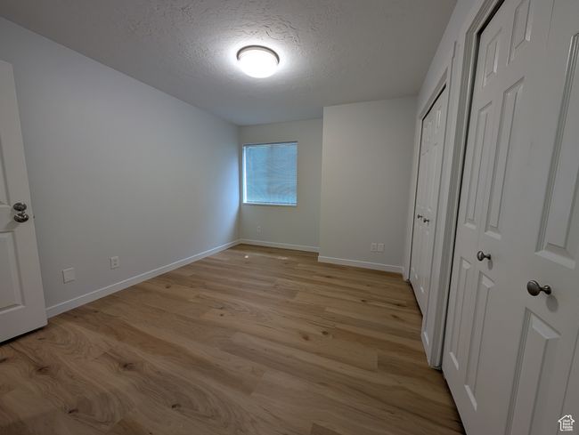 Unfurnished bedroom featuring light wood-style flooring and a textured ceiling | Image 22