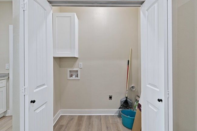 Laundry room featuring washer hookup, hookup for an electric dryer, light wood-style flooring, and baseboards | Image 12