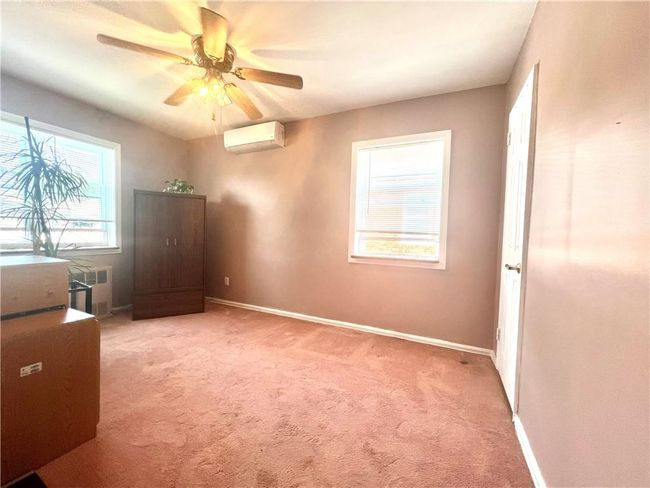 2nd Bedroom featuring ceiling fan, a wall unit AC, a healthy amount of sunlight, and radiator | Image 14