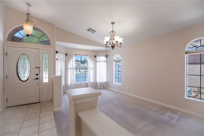 Entrance foyer with lofted ceiling, visible vents, a chandelier, and baseboards | Image 6