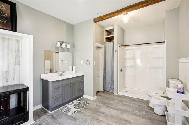 Bathroom featuring a shower stall, toilet, wood finished floors, vanity, and baseboards | Image 18