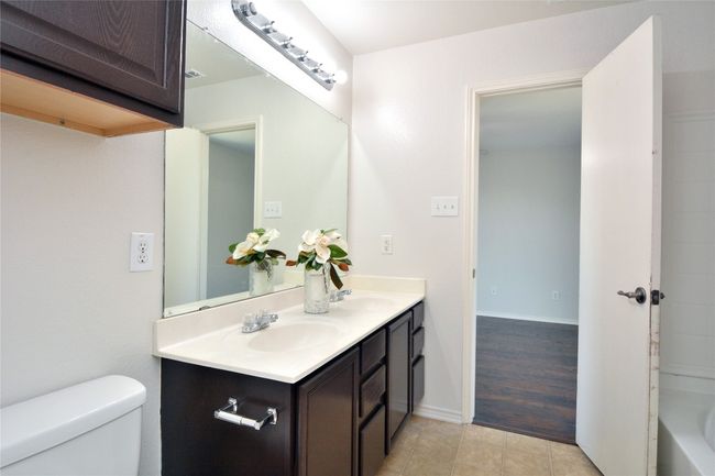 Full bath featuring double vanity, toilet, and tile patterned floors | Image 13