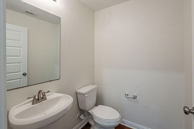 Bathroom with toilet, a sink, baseboards, and visible vents | Image 19