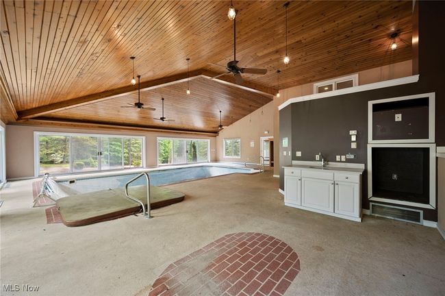View of swimming pool featuring a ceiling fan and a sink | Image 34