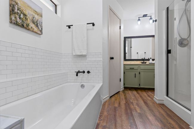Full bath with vanity, wood finished floors, a bath, and a stall shower | Image 19