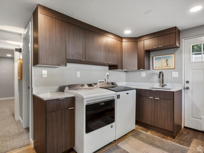Kitchen with washing machine and clothes dryer, light countertops, light wood-style floors, and recessed lighting | Image 18