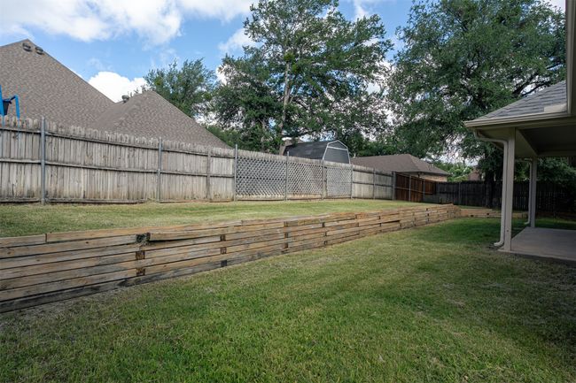 Fenced backyard with a patio | Image 35