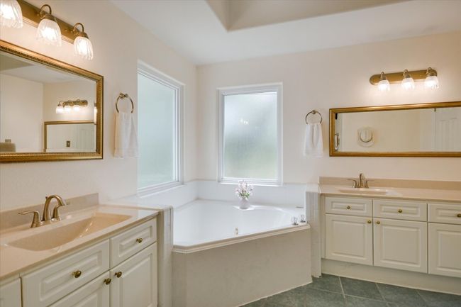 The bright and neutral design creates a spa-like ambiance in the primary bathroom. | Image 14