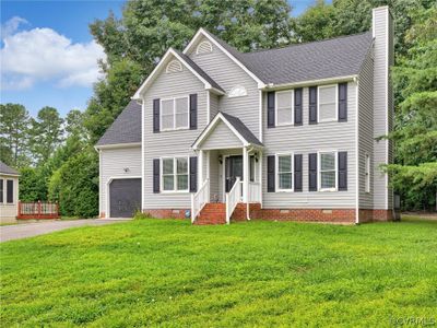 View of front of home featuring a garage and a front yard | Image 1