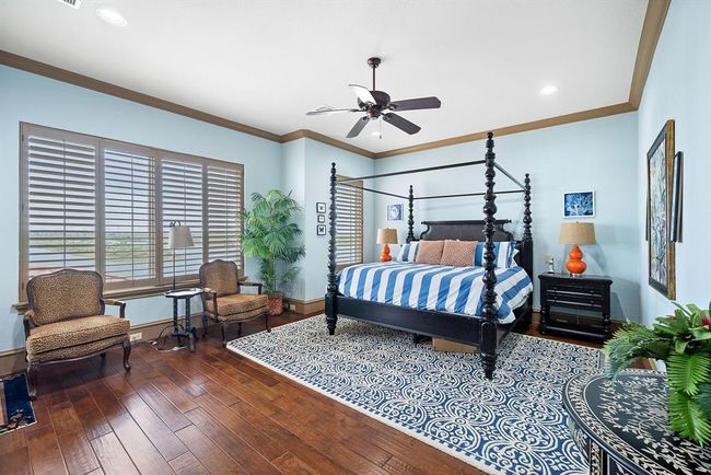 The large primary suite offers beautiful hardwood flooring and captivating waterfront views | Image 22