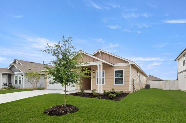 View of front of house with concrete driveway, board and batten siding, a front yard, central AC unit, and fence | Image 25
