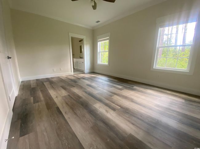Unfurnished room with a ceiling fan, dark wood finished floors, and crown molding | Image 23