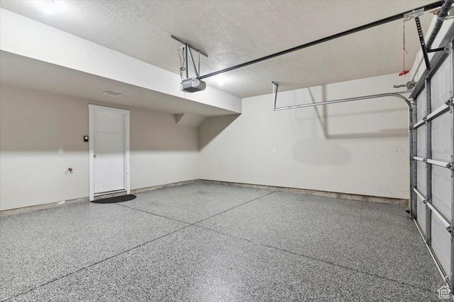 Garage featuring a garage door opener and baseboards | Image 30