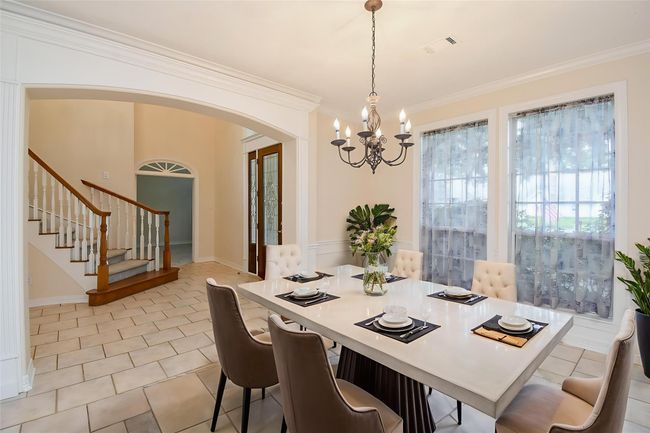 Bright and spacious room with large windows offering a lovely garden view. Features a tray ceiling with recessed lighting and a ceiling fan, perfect for comfort and style. The patterned carpet adds warmth to the space. *Virtually staged | Image 11
