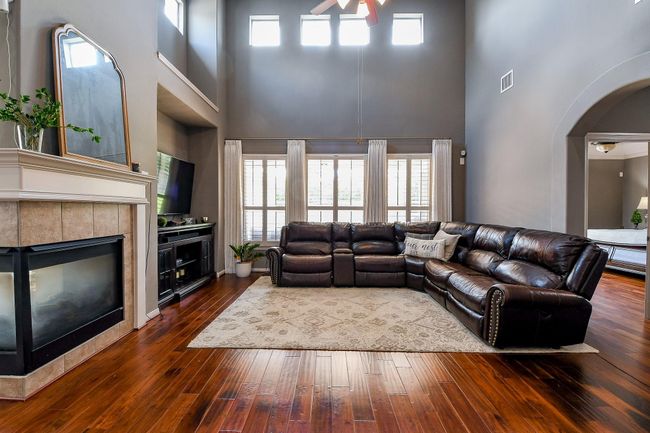Warm and welcoming two story family room bathed in natural light featuring rich wood floors | Image 18