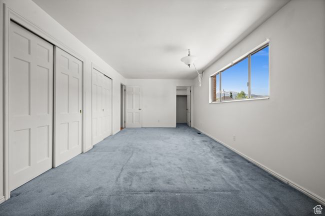 Unfurnished bedroom featuring carpet floors, two closets, and baseboards | Image 21