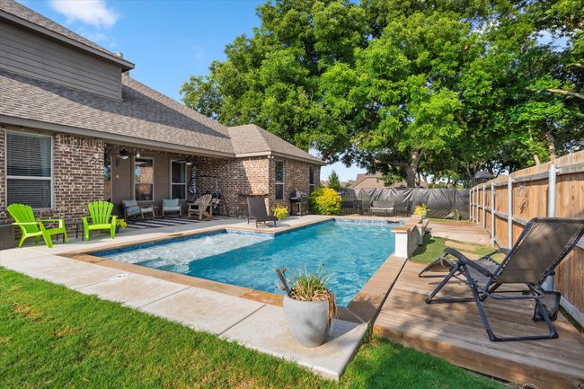 View of pool with a fenced in pool, a fenced backyard, and a wooden deck | Image 31