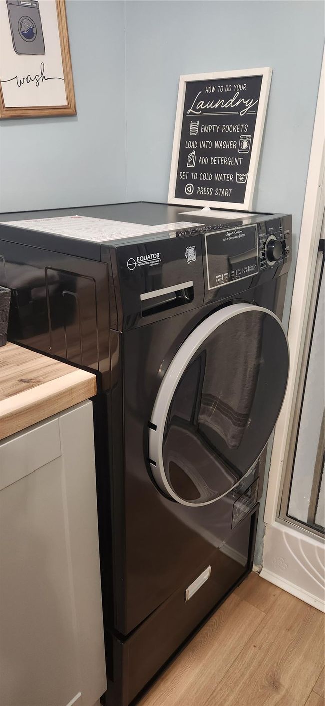Washroom featuring laundry area, washer / dryer, and wood finished floors | Image 22