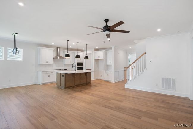 Photo represents the plan, not the actual home. Design selections may vary. A spacious kitchen with an island and pantry open to an adjoining dining area and the family room. | Image 19