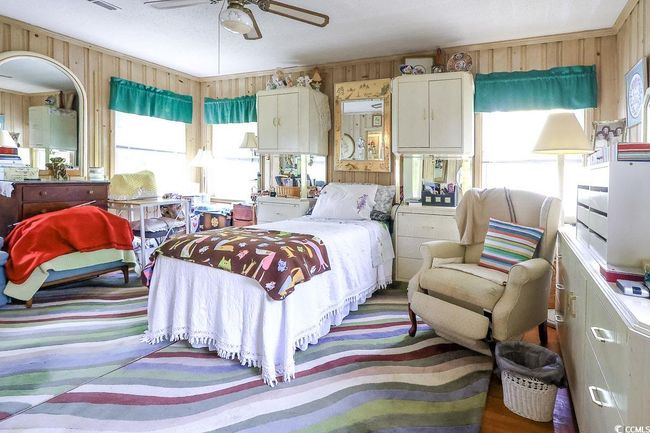 Bedroom with wooden walls and a ceiling fan | Image 9
