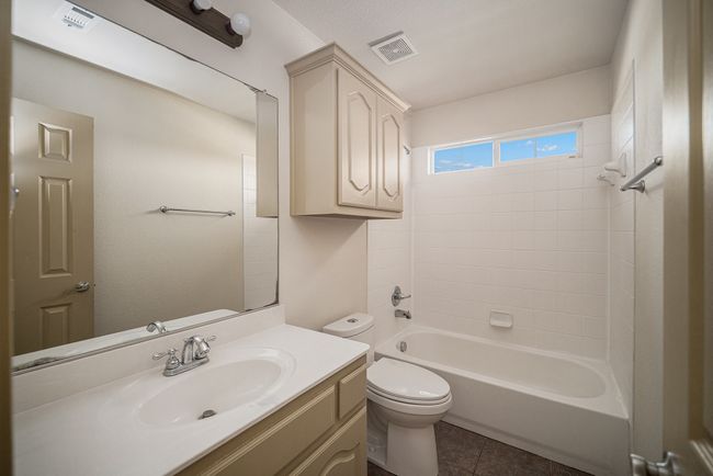 Full bathroom featuring toilet, vanity, tile patterned flooring, and shower combination | Image 15